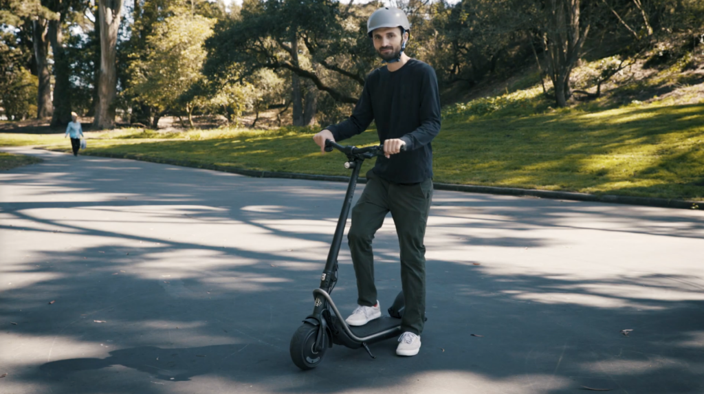 a man on a boosted rev electric scooter with a helmet on because safety